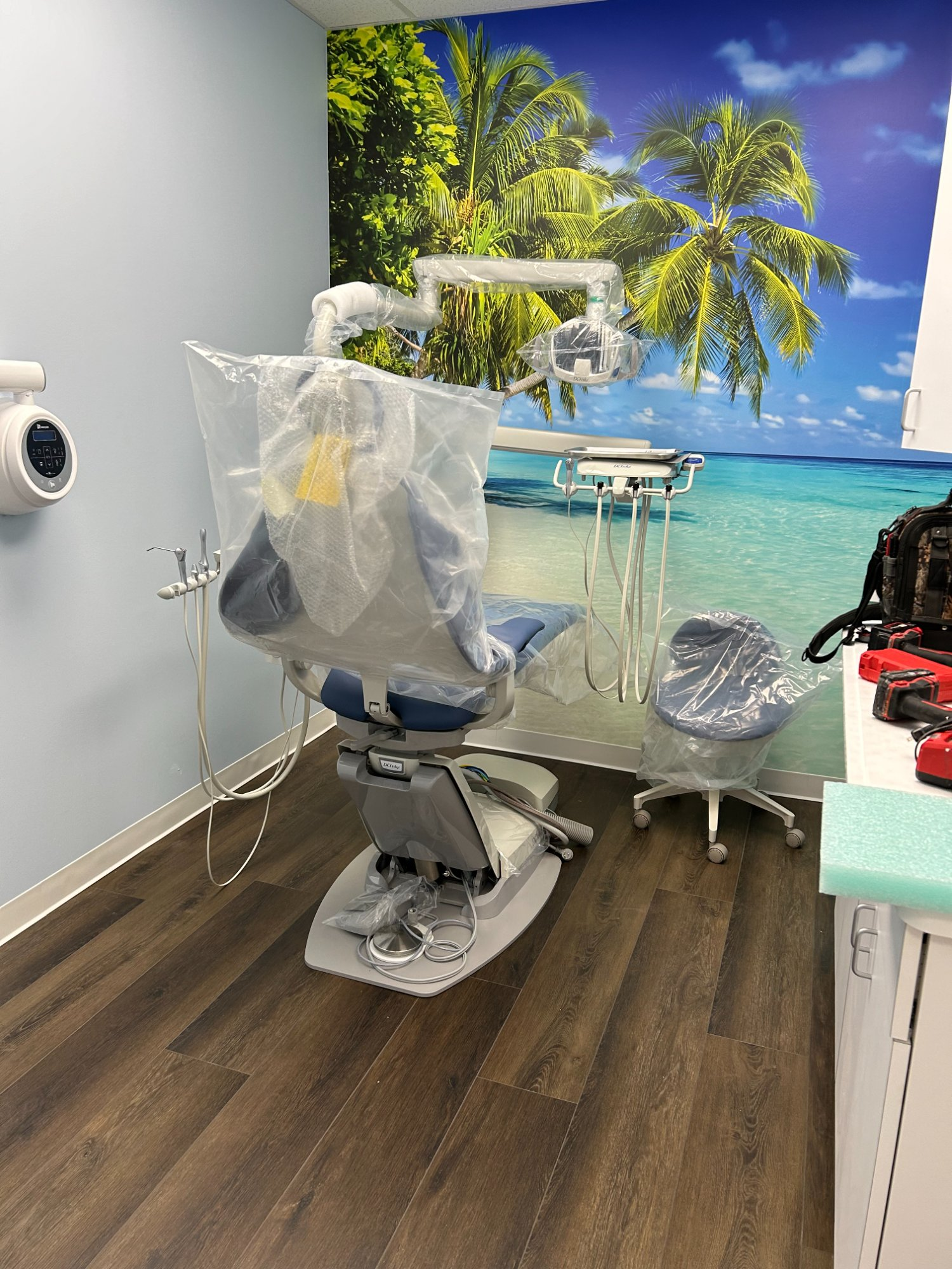 A-dec dental chair installed in operatory with tropical beach mural wall
