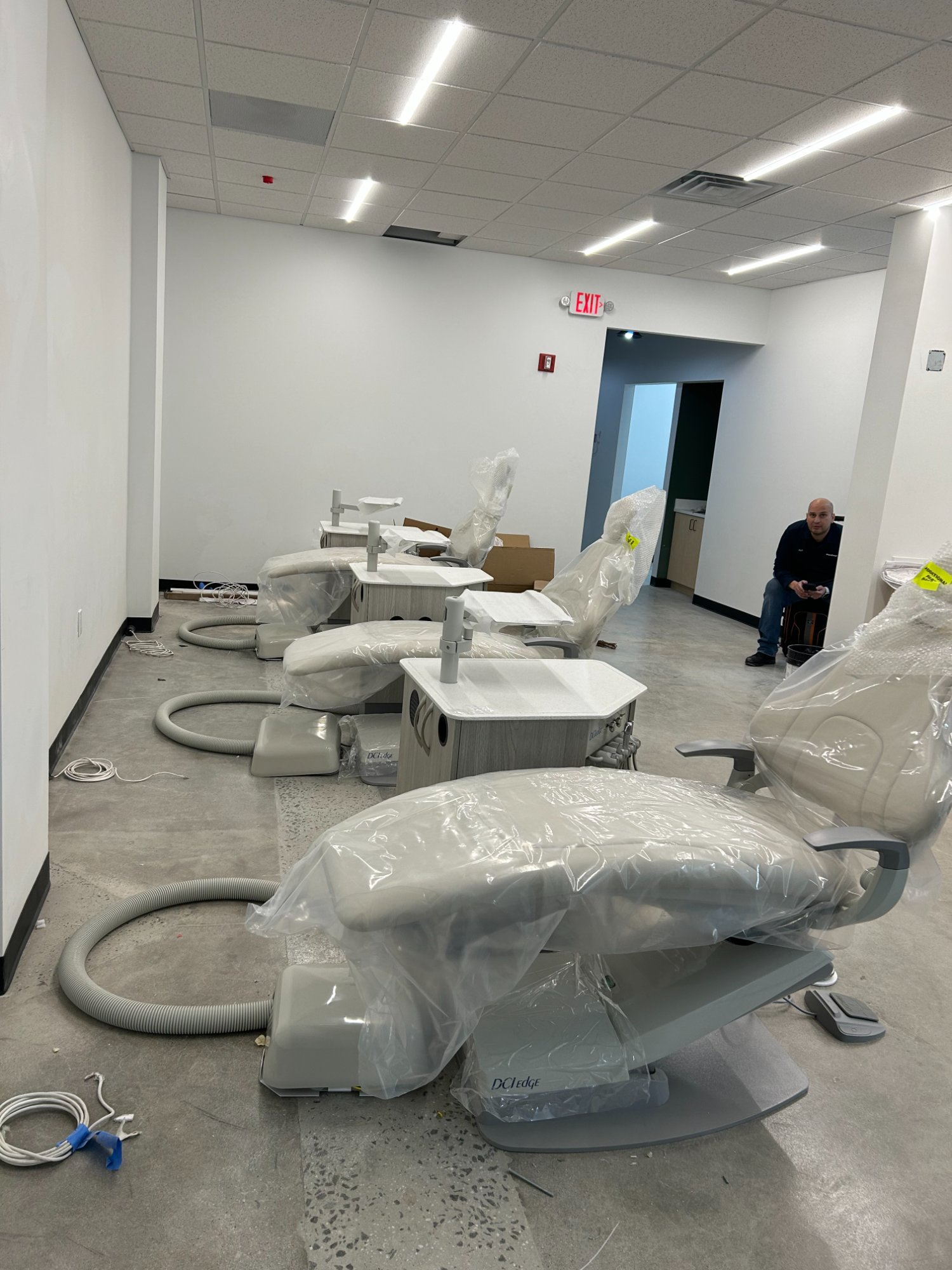 Multiple DCI Edge dental chairs staged for installation in open-plan dental clinic buildout