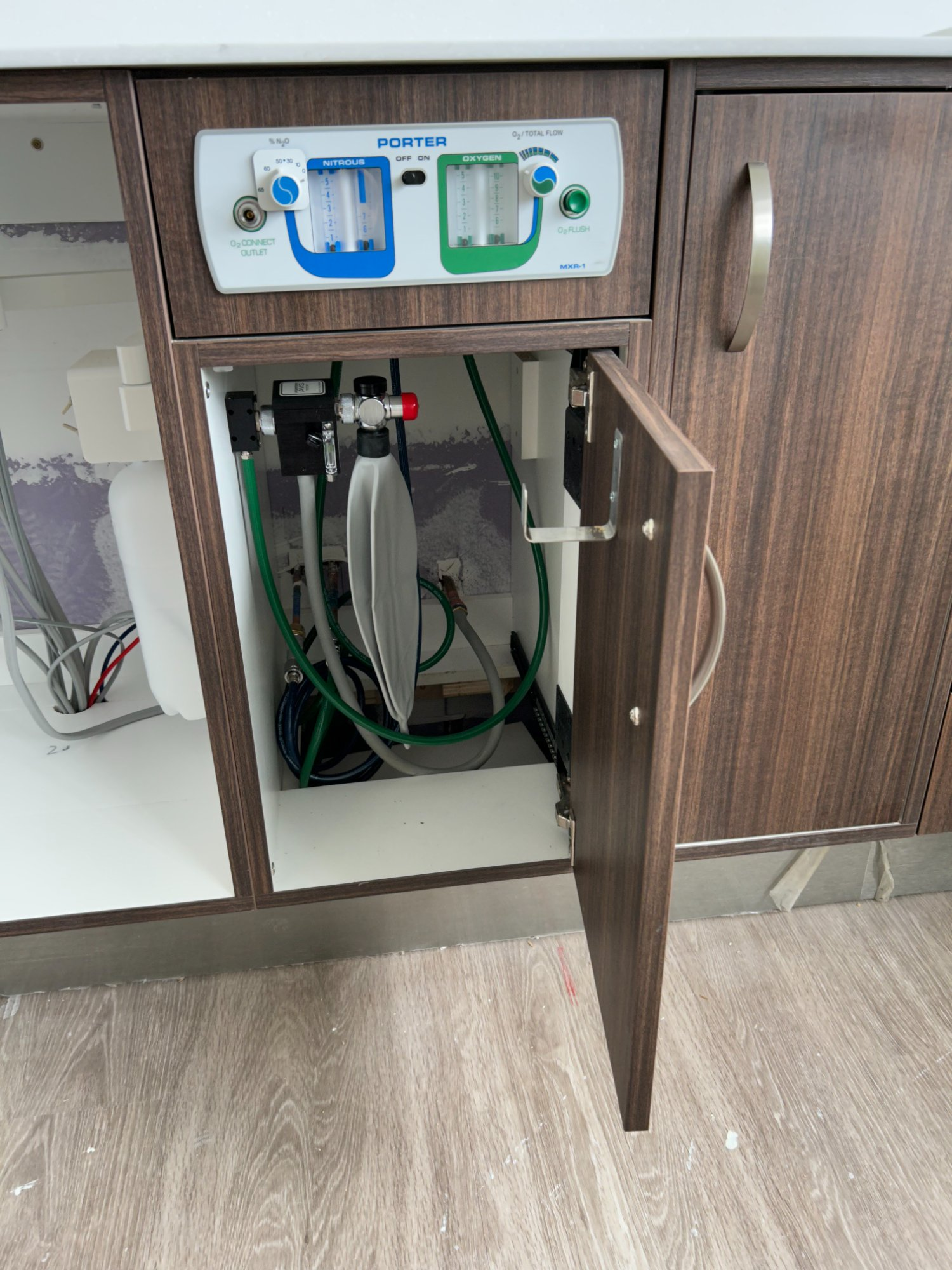 Porter nitrous oxide and oxygen delivery system installed inside dental cabinet with gas lines