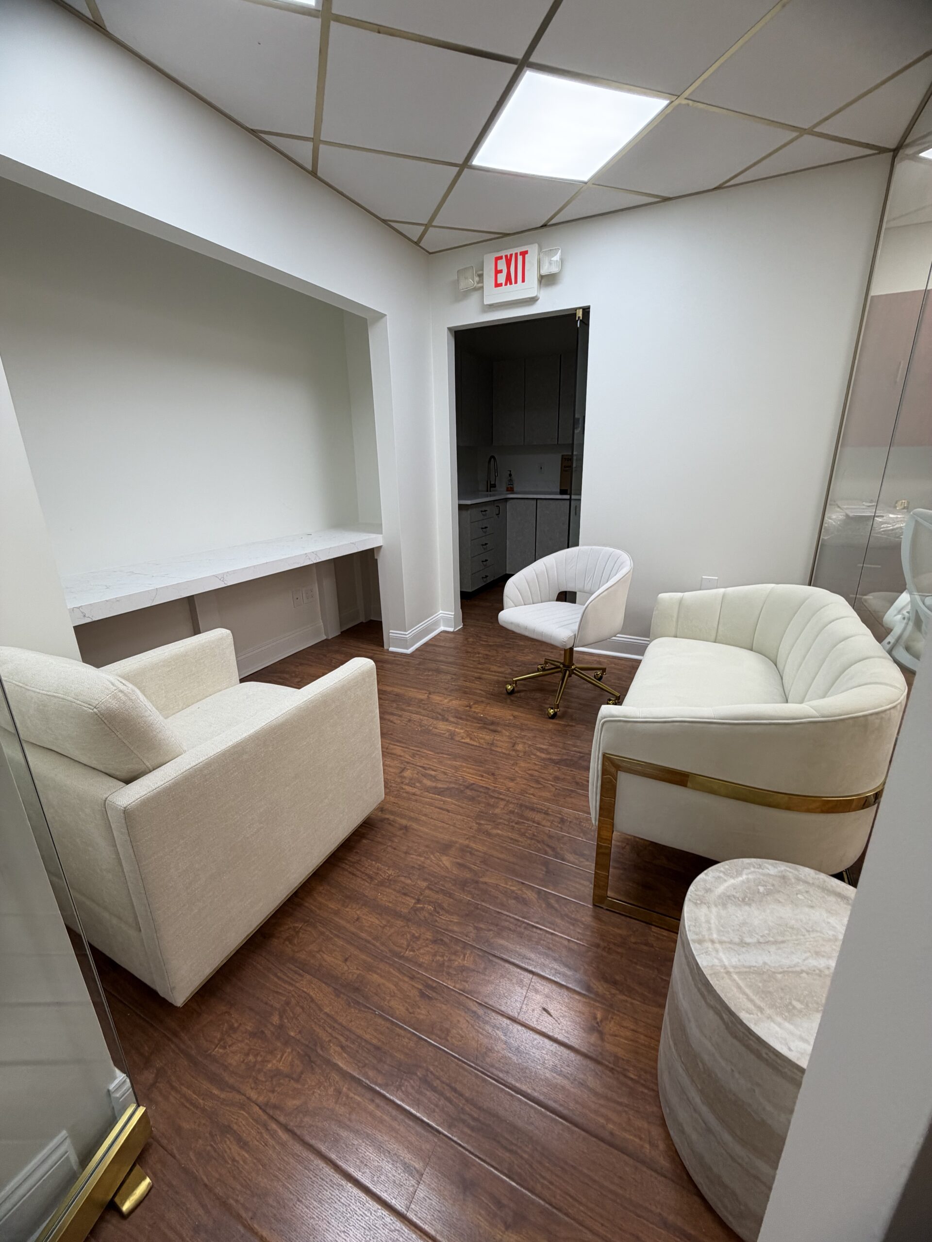 Private dental consultation room enclosed by a fluted glass wall and navy-and-gold glass doors